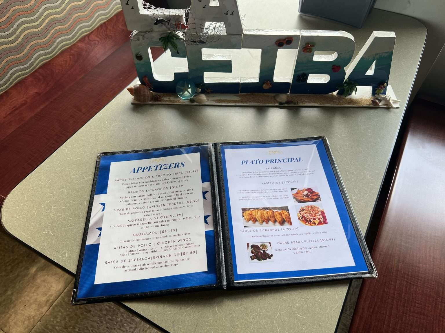 A menu is sitting on a table next to a sign that says ceba.