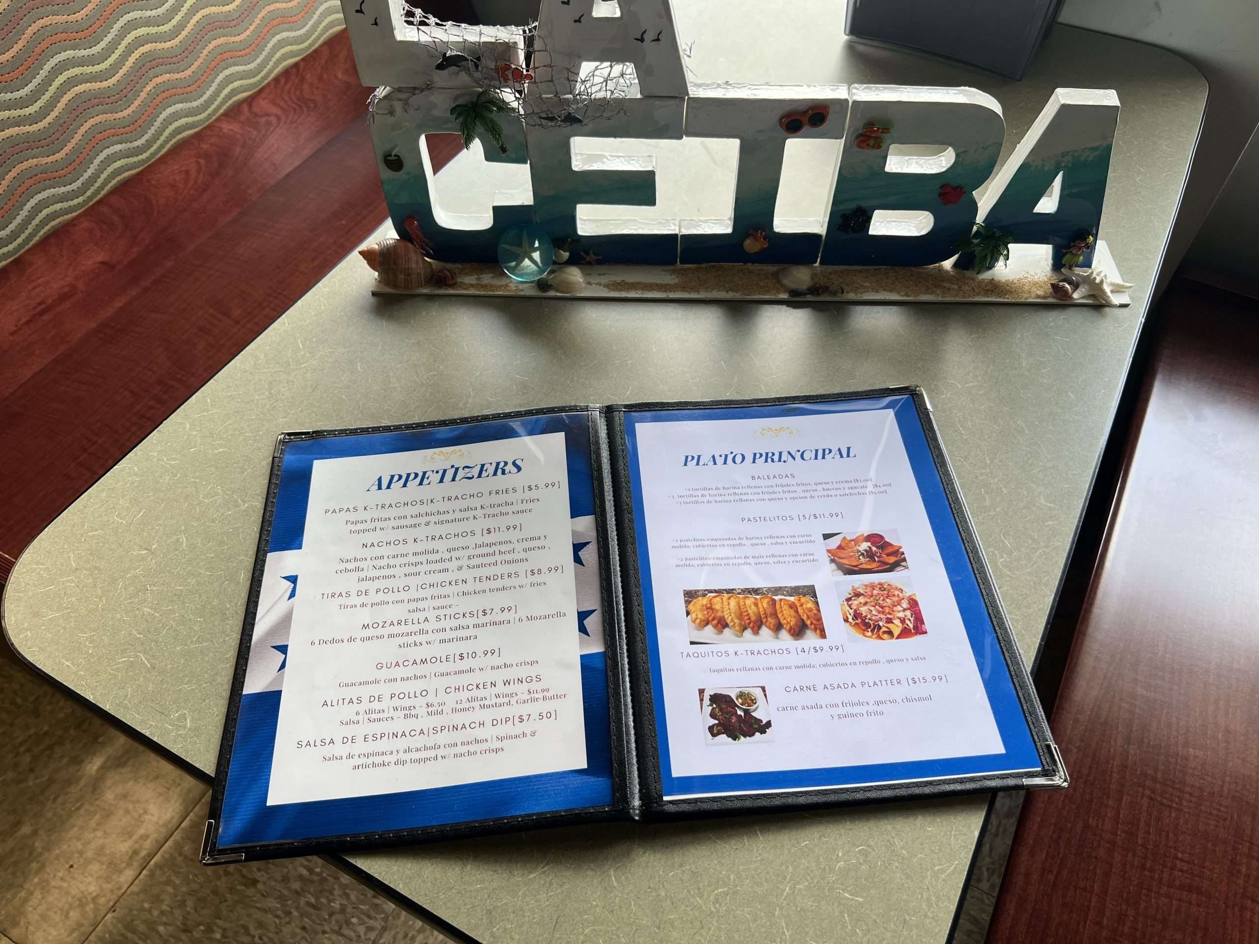 A menu is sitting on a table next to a sign that says ceba.