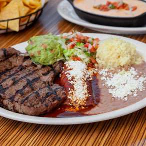 A plate with a steak and guacamole.