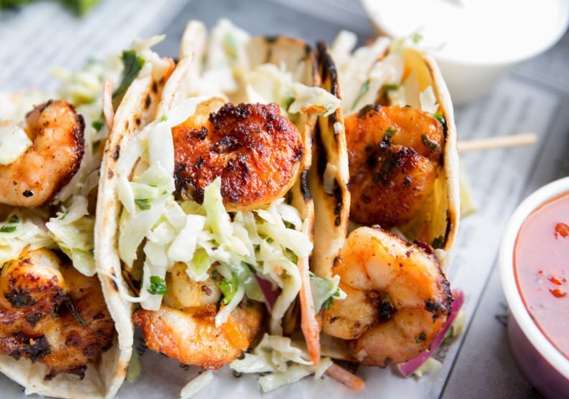 Shrimp tacos with coleslaw and dipping sauce.